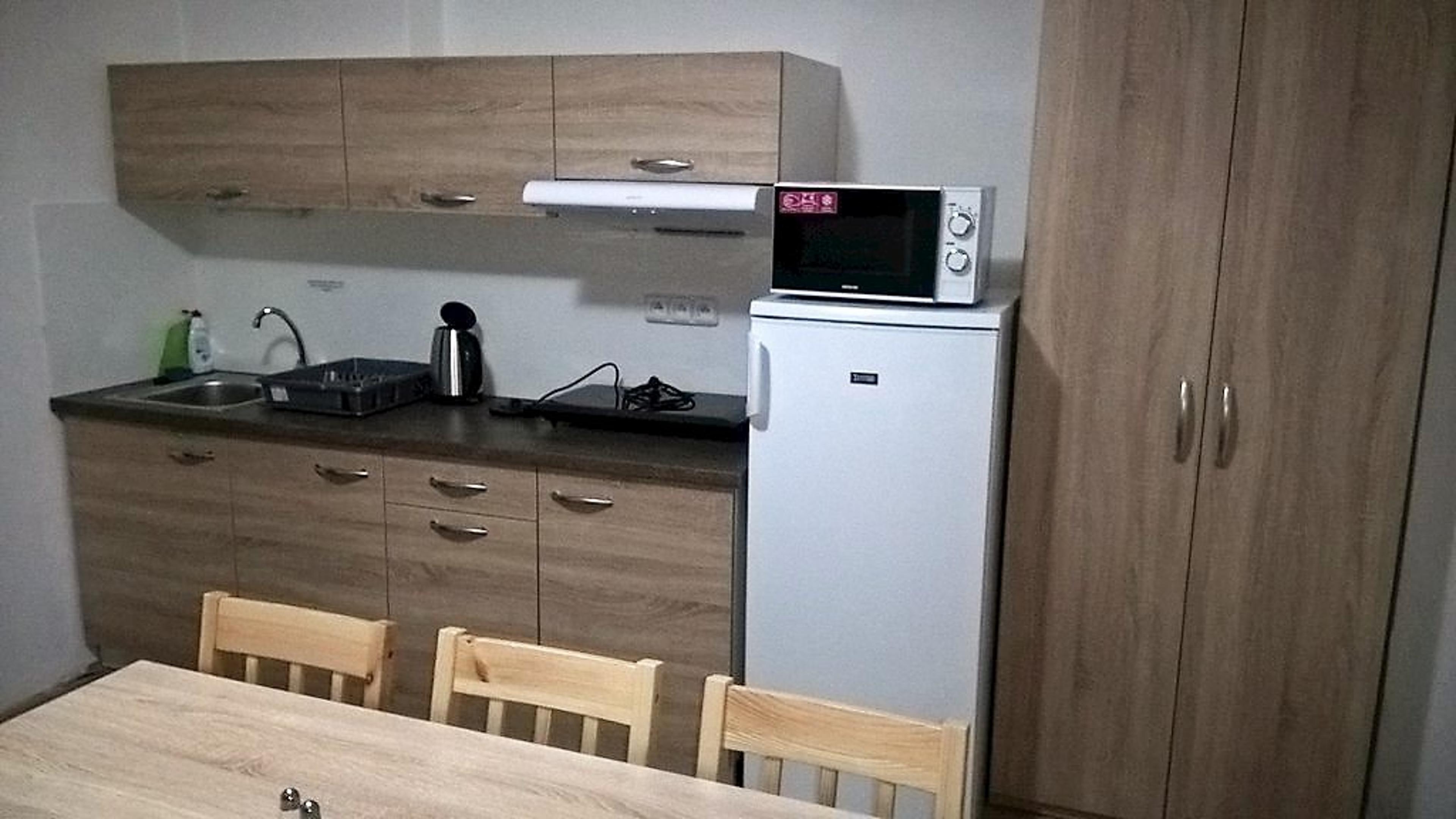 Dvoulůžkový pokoj ve kterém se nachází také kuchyňský kout a jídelní stůl se šesti židlemi. - Ubytování u Holušů